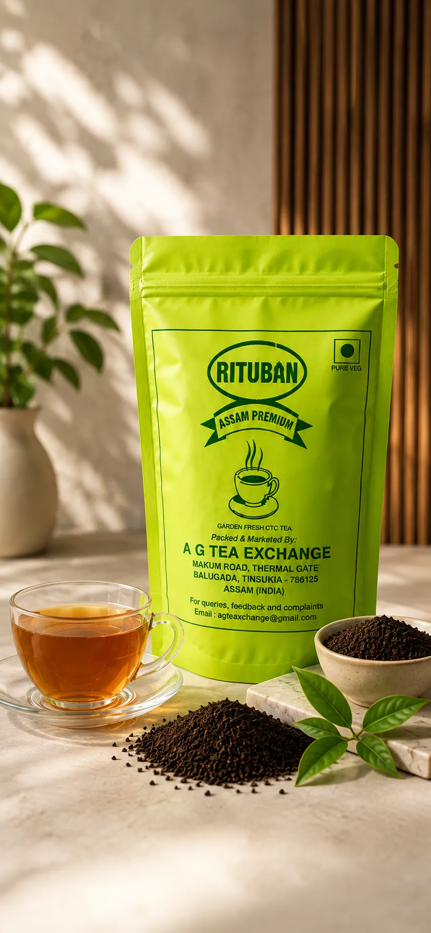 Rituban Assam Tea pack with tea leaves and brewed cup on a tea garden background